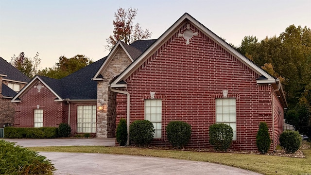 property exterior at dusk featuring a yard