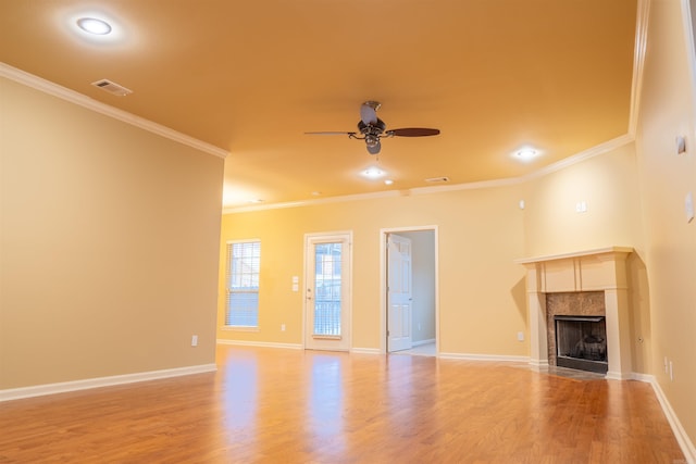 unfurnished living room featuring light hardwood / wood-style flooring, a tiled fireplace, and crown molding