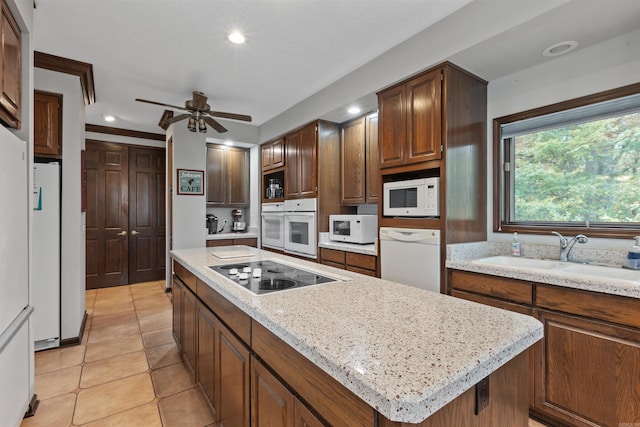 kitchen with a kitchen island, sink, light tile patterned floors, white appliances, and ceiling fan