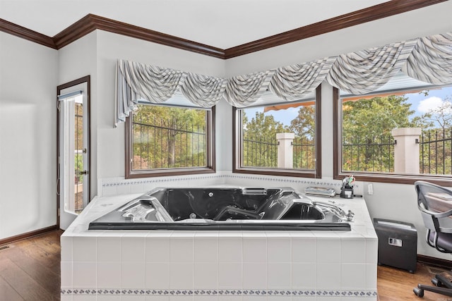 bathroom with a relaxing tiled tub, crown molding, hardwood / wood-style flooring, and a healthy amount of sunlight