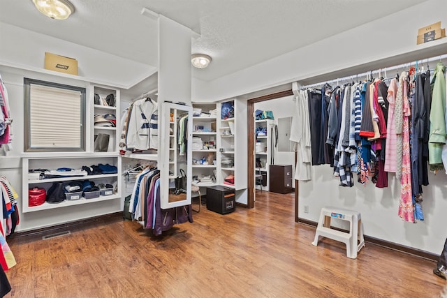 walk in closet with hardwood / wood-style flooring