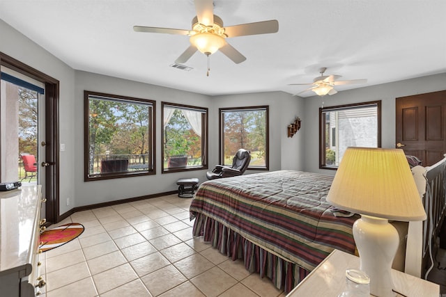 bedroom with ceiling fan, multiple windows, and light tile patterned floors