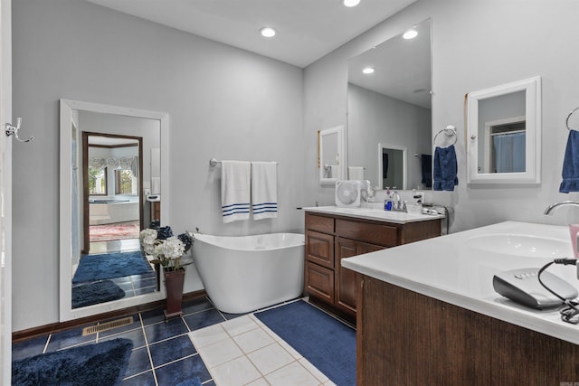 bathroom featuring vanity, a tub to relax in, and tile patterned flooring