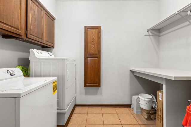 laundry area with light tile patterned flooring, independent washer and dryer, and cabinets