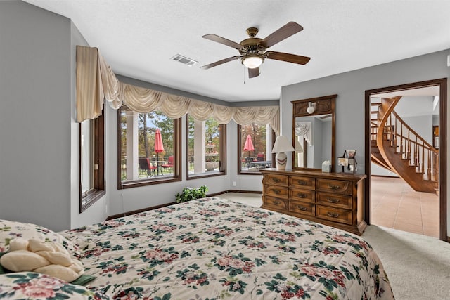 tiled bedroom with ceiling fan and a textured ceiling