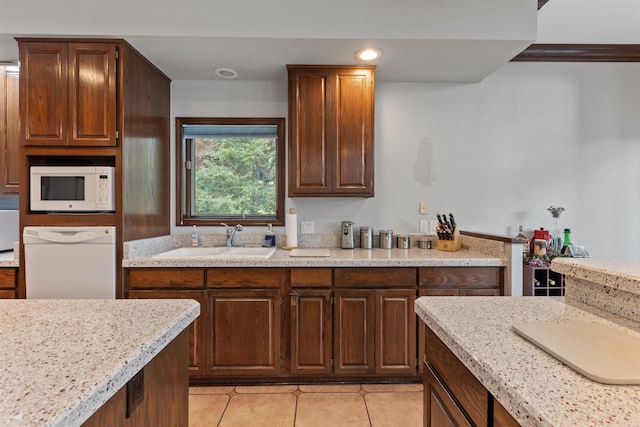 kitchen featuring light tile patterned flooring, light stone countertops, sink, and white appliances