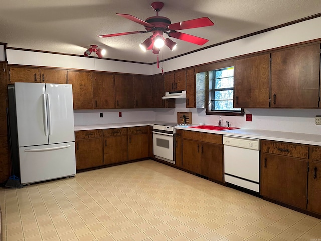 kitchen featuring a textured ceiling, dark brown cabinets, sink, and white appliances