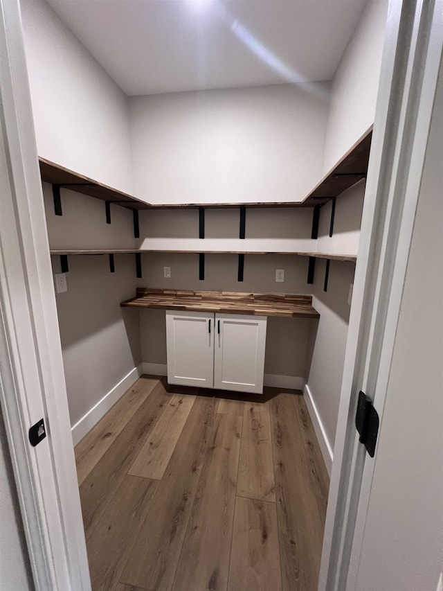 clothes washing area with light hardwood / wood-style floors