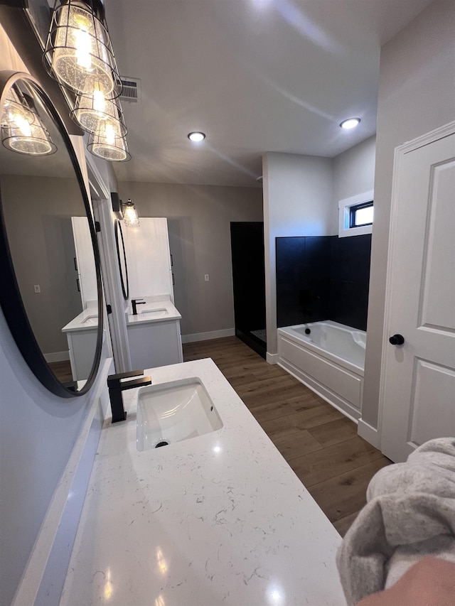 bathroom featuring a bathing tub, wood-type flooring, and vanity