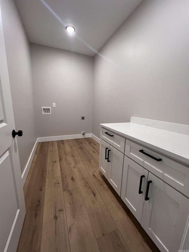 washroom with washer hookup, cabinets, light hardwood / wood-style floors, and hookup for an electric dryer