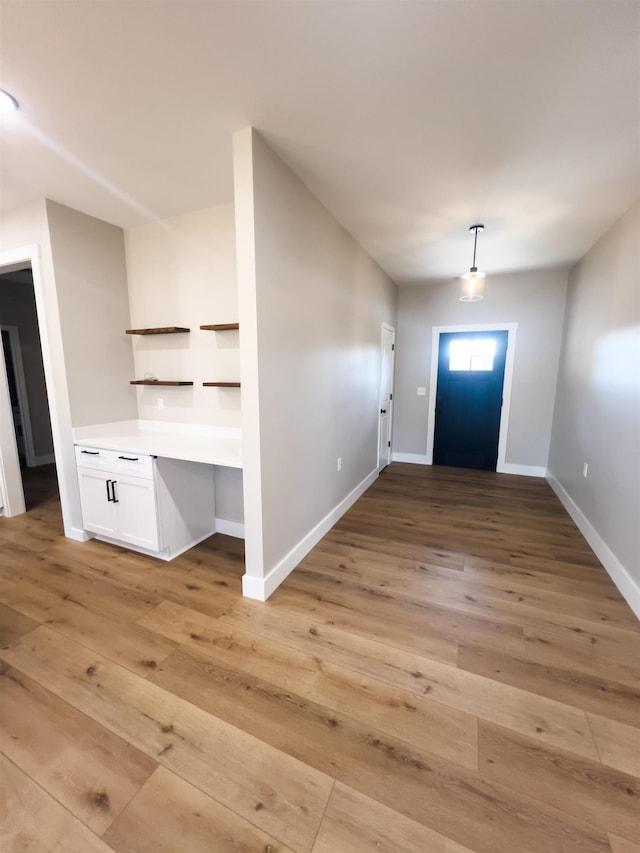 foyer with built in desk and light wood-type flooring