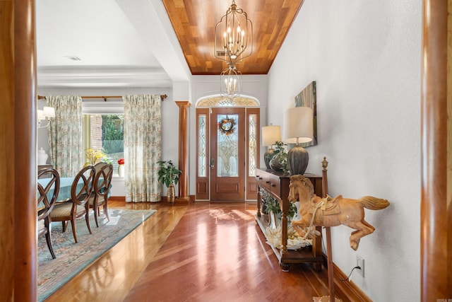 entrance foyer featuring lofted ceiling, wood-type flooring, an inviting chandelier, and wooden ceiling