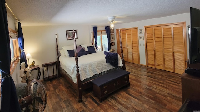 bedroom with a textured ceiling, multiple closets, dark hardwood / wood-style flooring, and ceiling fan