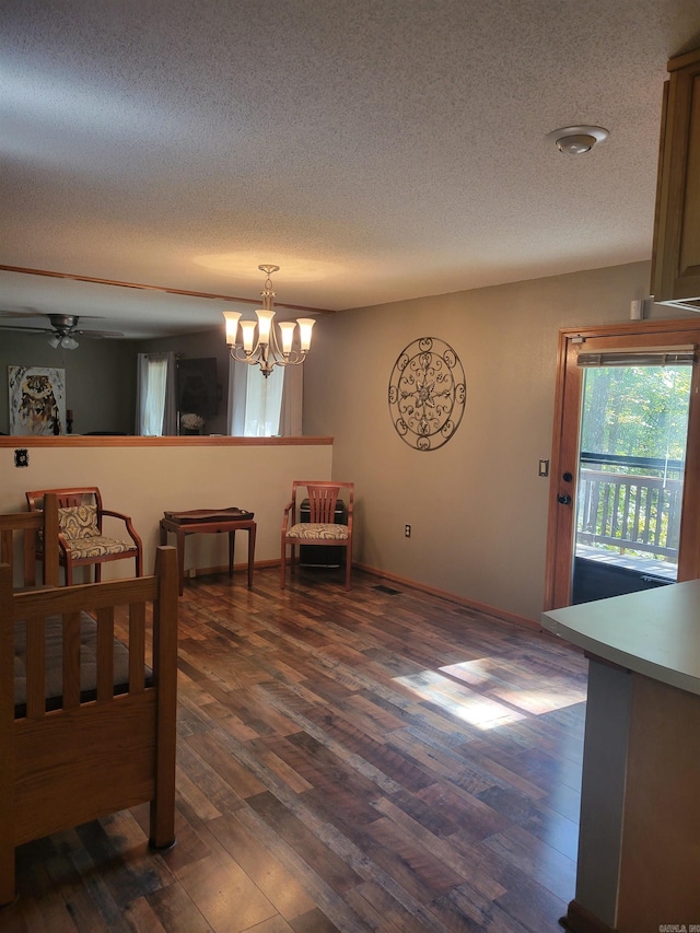 interior space with dark wood-type flooring, a textured ceiling, and ceiling fan with notable chandelier