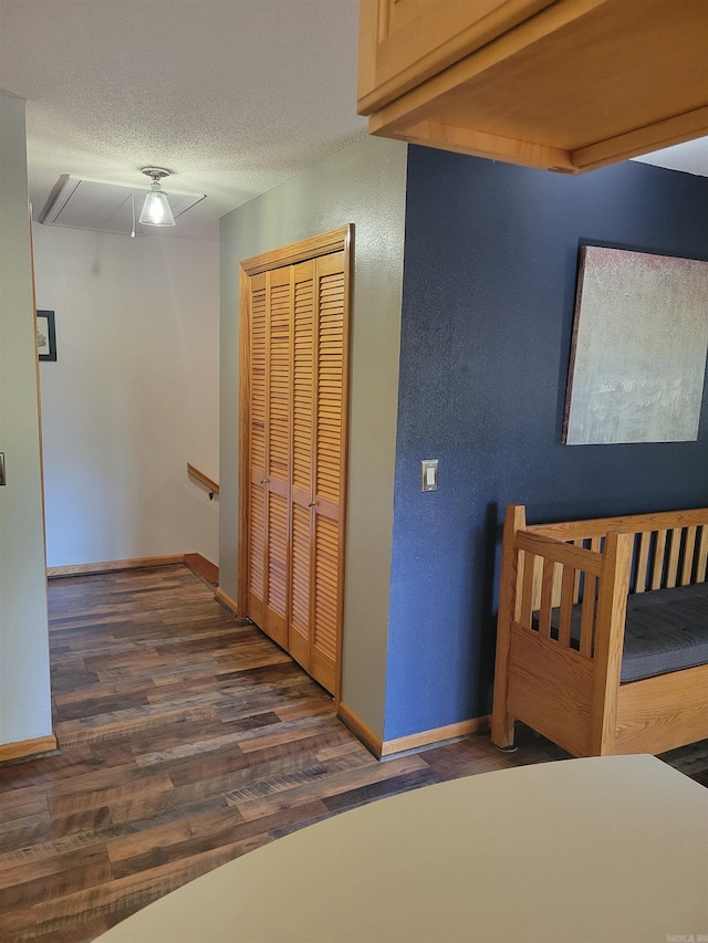 hallway with dark wood-type flooring and a textured ceiling