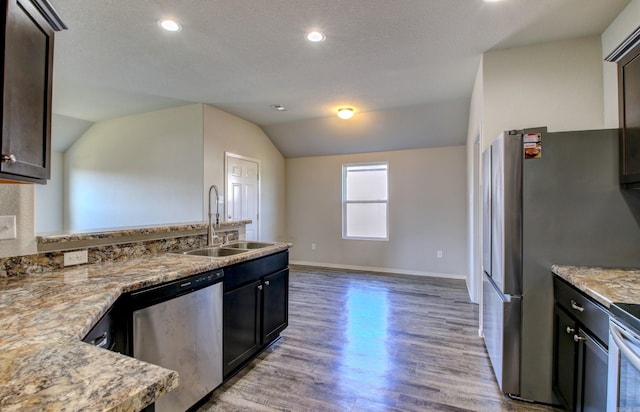 kitchen featuring dark brown cabinets, stainless steel appliances, hardwood / wood-style floors, sink, and vaulted ceiling