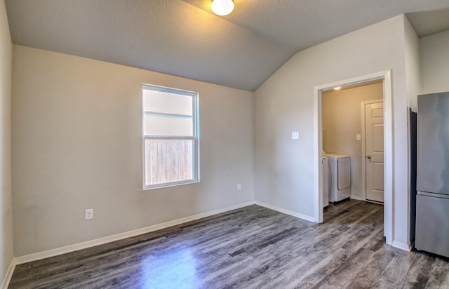 empty room with independent washer and dryer, dark hardwood / wood-style floors, a textured ceiling, and lofted ceiling