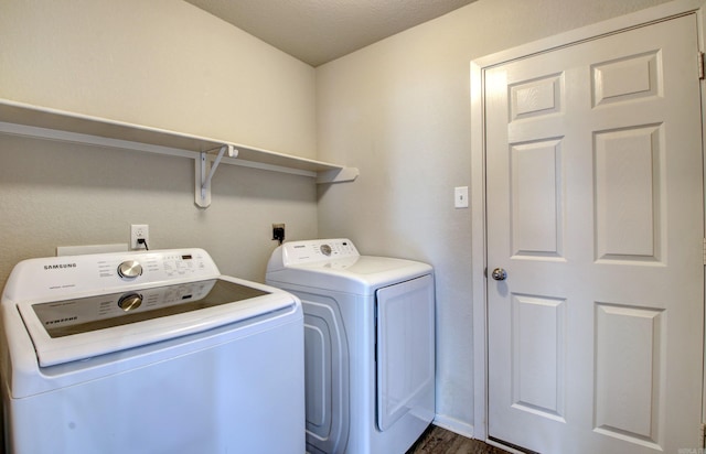 laundry area featuring dark hardwood / wood-style floors, a textured ceiling, and washer and clothes dryer