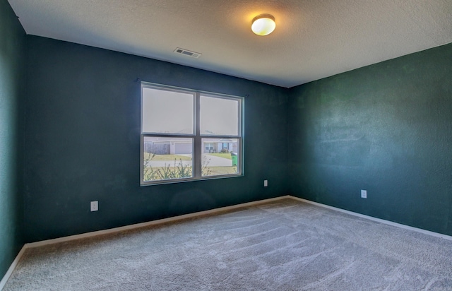 unfurnished room featuring a textured ceiling and carpet floors