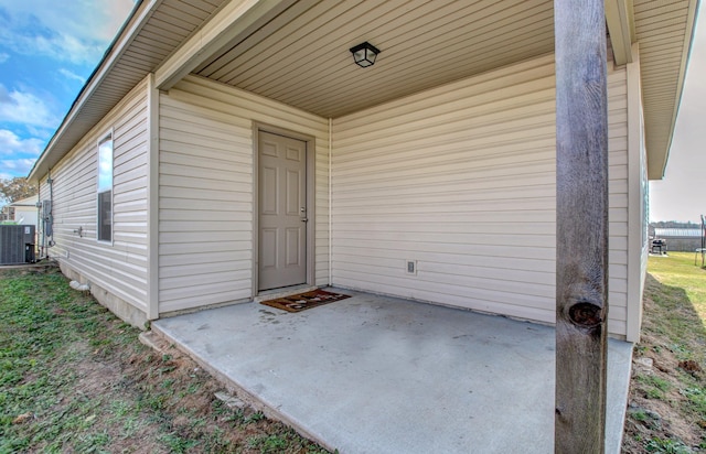 view of exterior entry featuring a patio and cooling unit