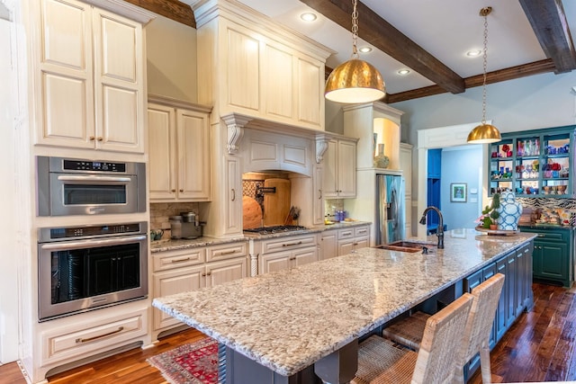 kitchen featuring dark hardwood / wood-style floors, beamed ceiling, sink, and a center island with sink