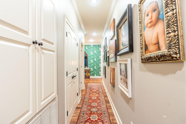 hallway with ornamental molding and hardwood / wood-style flooring