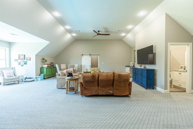 carpeted living room featuring vaulted ceiling, a barn door, and ceiling fan