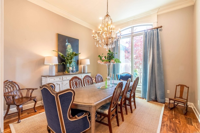 dining space with a notable chandelier, ornamental molding, and dark hardwood / wood-style flooring