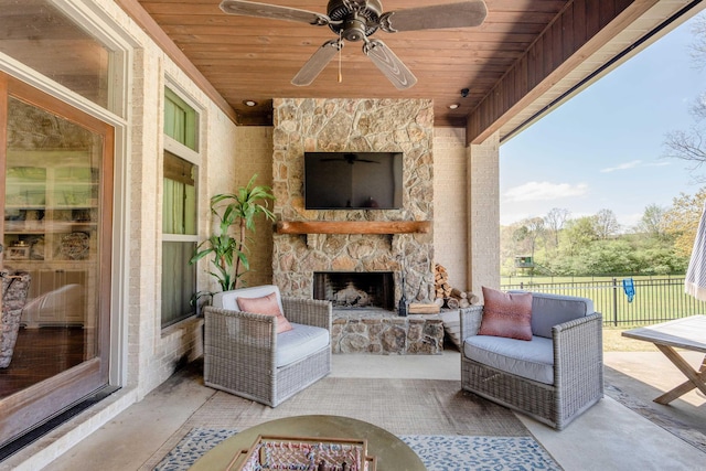 view of patio with an outdoor living space with a fireplace and ceiling fan