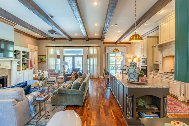 living room with a fireplace, beamed ceiling, ornamental molding, and dark hardwood / wood-style floors