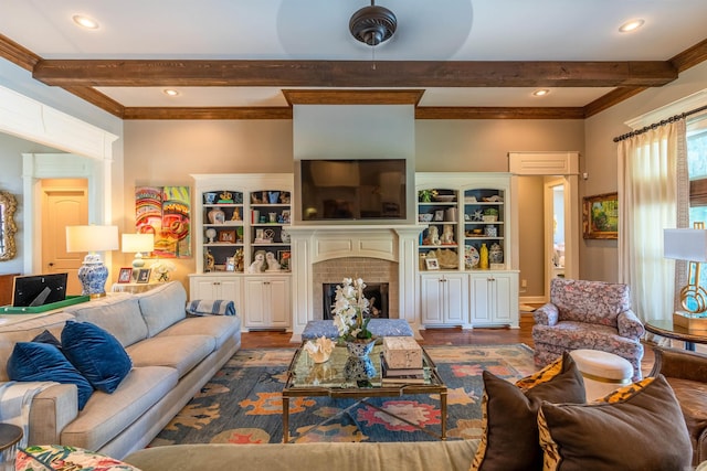 living room with beam ceiling, hardwood / wood-style floors, and a brick fireplace