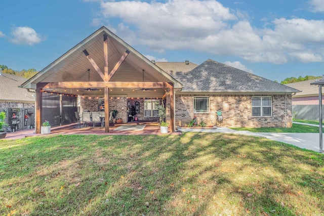 rear view of property with a patio and a lawn