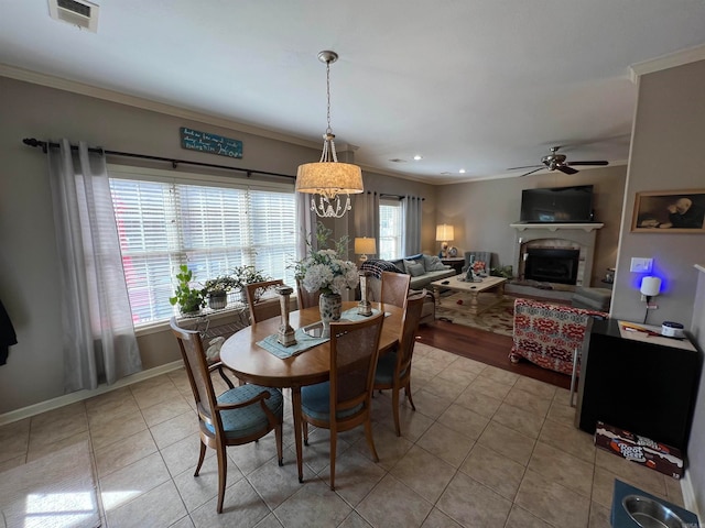 dining space featuring ornamental molding, ceiling fan with notable chandelier, and a healthy amount of sunlight