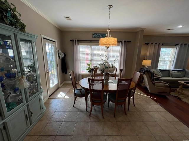 tiled dining space featuring crown molding