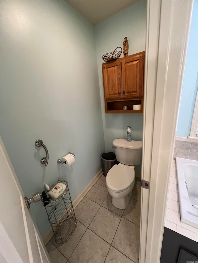 bathroom featuring toilet, tile patterned floors, sink, and a tub