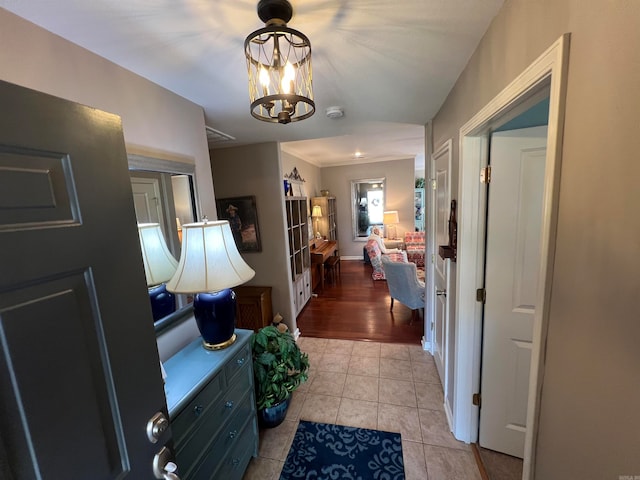 hallway with an inviting chandelier and light wood-type flooring