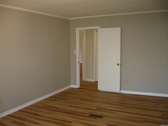 spare room with ornamental molding and hardwood / wood-style flooring