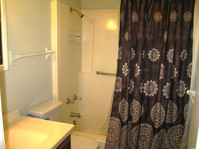 full bathroom featuring toilet, shower / bath combo with shower curtain, and vanity