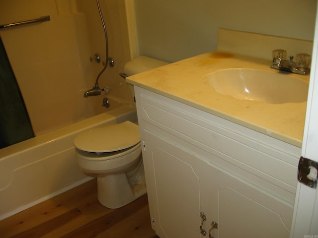 full bathroom with toilet, hardwood / wood-style flooring, vanity, and washtub / shower combination