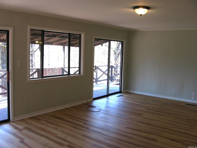 empty room featuring crown molding and hardwood / wood-style flooring