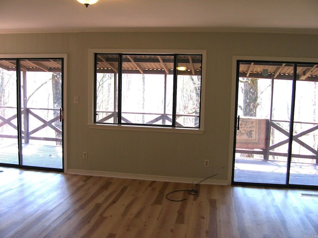 doorway to outside with a wealth of natural light and hardwood / wood-style flooring