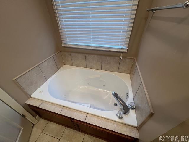 bathroom with a relaxing tiled tub and tile patterned floors