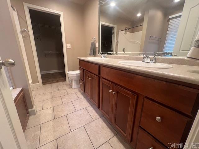 bathroom with vanity, a shower, toilet, and tile patterned floors