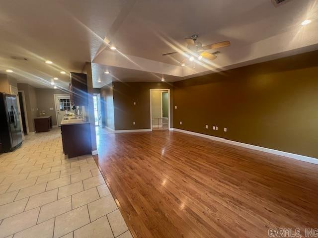 kitchen with lofted ceiling, stainless steel fridge, light hardwood / wood-style floors, and ceiling fan