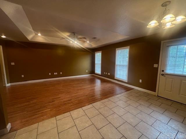 interior space featuring a notable chandelier, light hardwood / wood-style flooring, and a raised ceiling