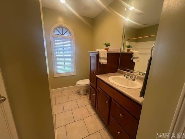 bathroom featuring vanity, a shower, toilet, and tile patterned flooring