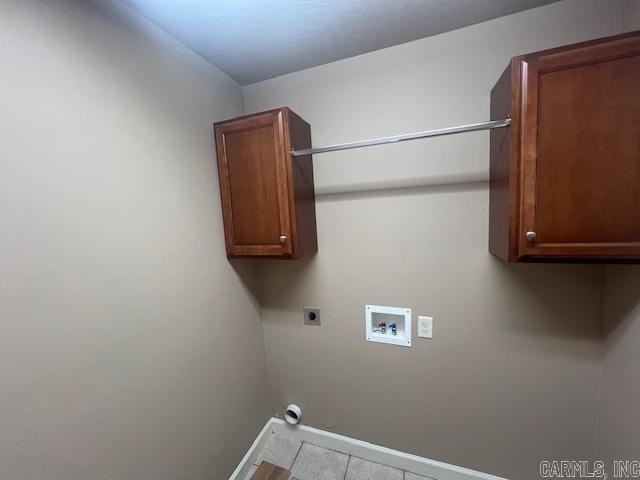 clothes washing area with cabinets, hookup for an electric dryer, light tile patterned flooring, and washer hookup