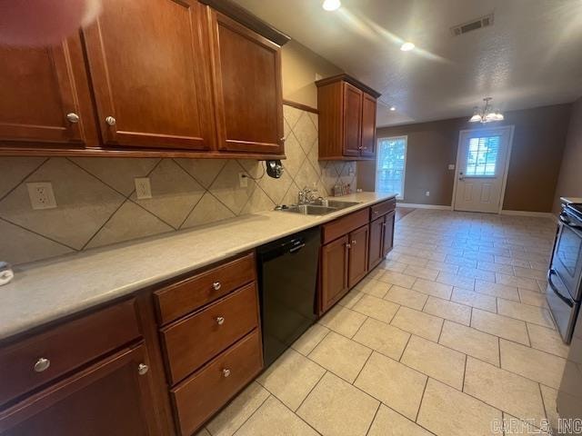 kitchen with black dishwasher, stainless steel stove, backsplash, sink, and a chandelier