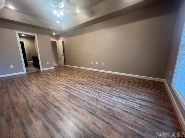 unfurnished room with dark hardwood / wood-style floors and ceiling fan