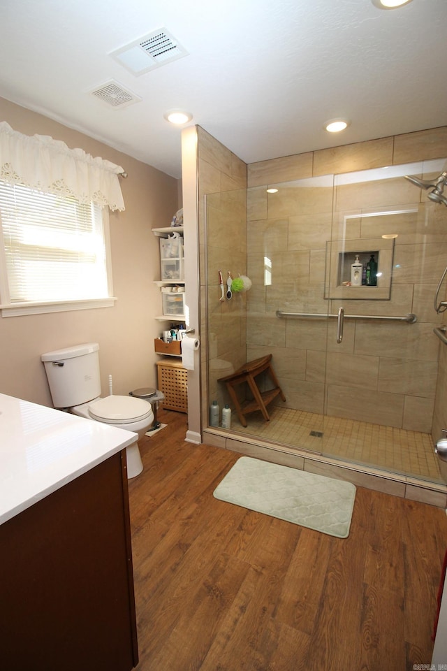 bathroom with vanity, toilet, wood-type flooring, and walk in shower